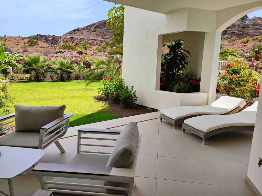 パルム・マールにあるGarden Suites luxury apartmentの庭園の景色を望むパティオ(椅子付)