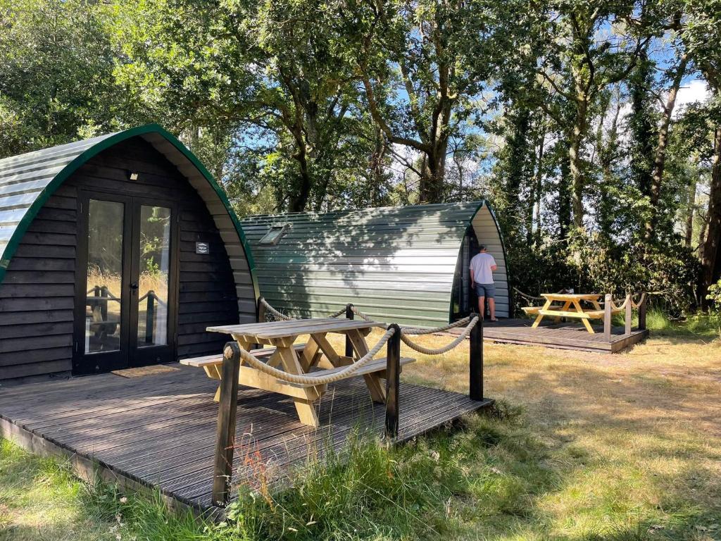 Cabaña con terraza de madera con banco y mesa en Nightjar Cabin at Cloudshill Glade en Wareham