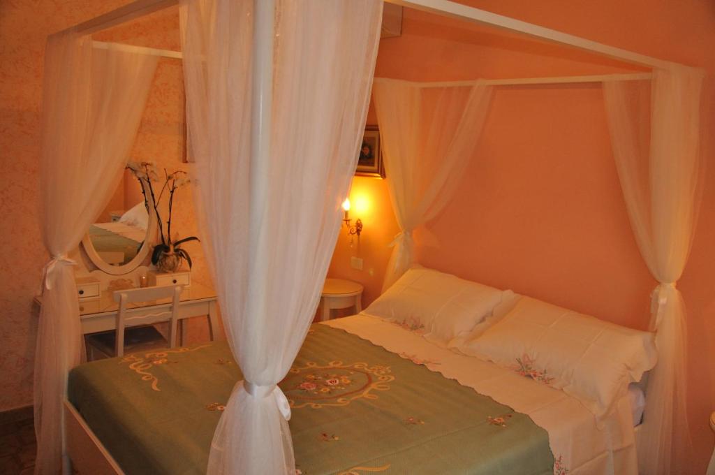 a bedroom with a canopy bed with white curtains at B&B Nonna Luisa in Tarquinia