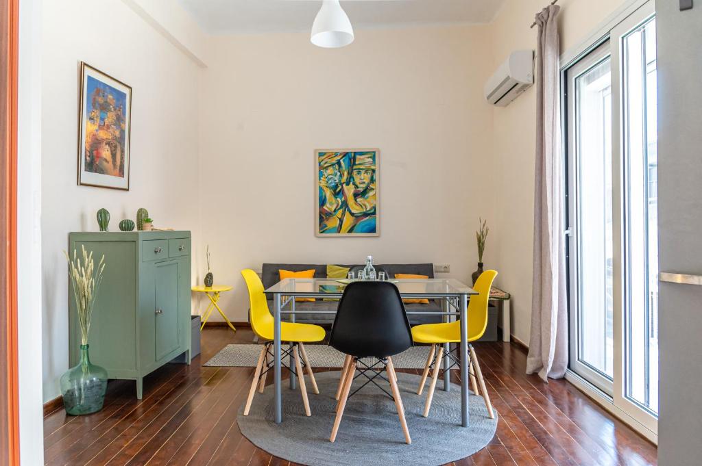 a dining room with a table and yellow chairs at Traditional 2-storey Μaisonette with Terrace in Heraklio