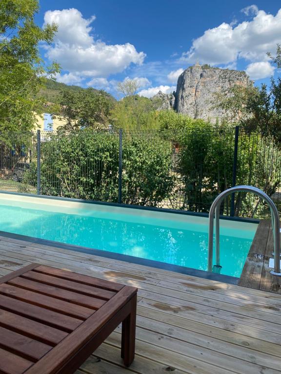 a swimming pool with a wooden bench next to it at Camping Frédéric Mistral in Castellane