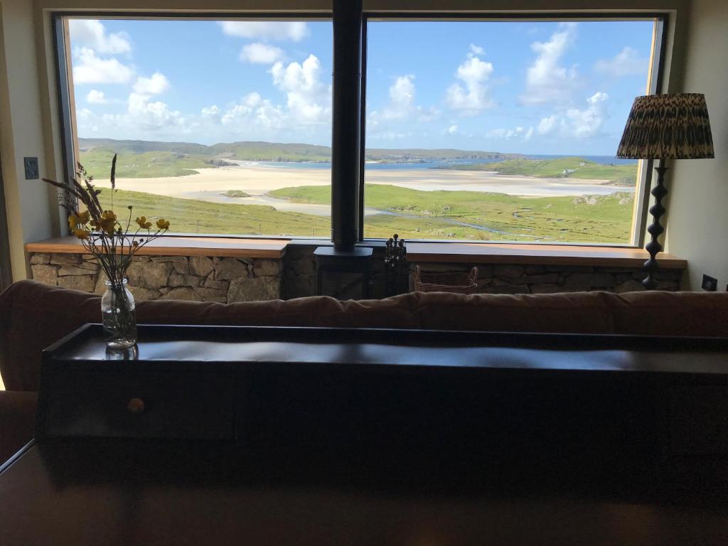 a living room with a couch and a large window at Uig Sands Rooms in Uig