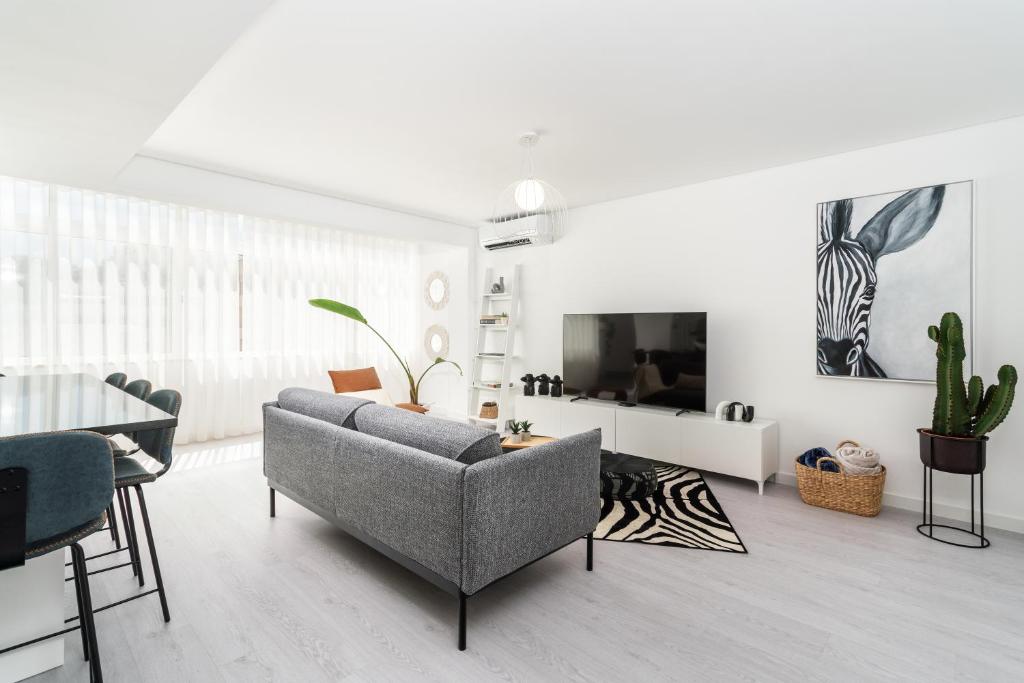 a living room with a couch and a tv at Privilege Deluxe Apartment Casa Mãe, Faro in Faro