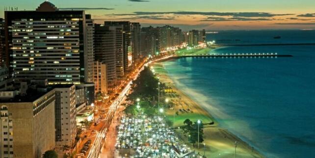 a night view of a beach with buildings and the ocean at Apartamento BEIRA MAR in Fortaleza