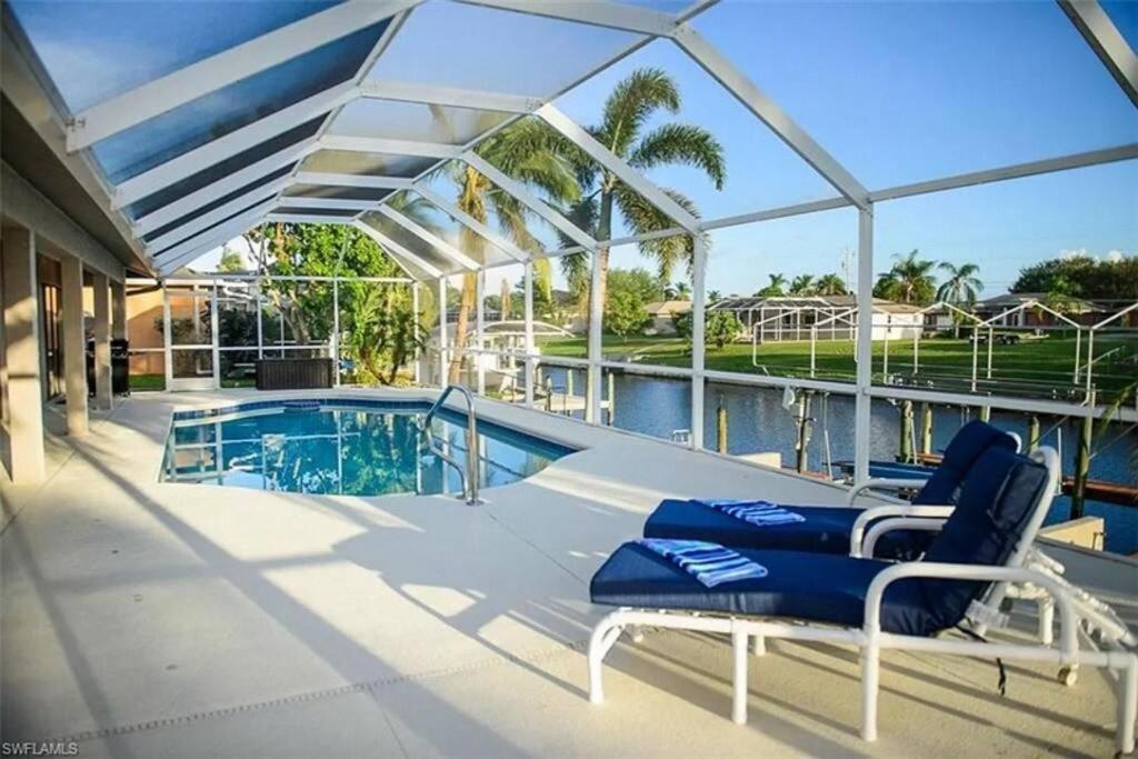 a swimming pool with two lounge chairs next to a building at Cape Coral Water Front Paradise in Cape Coral