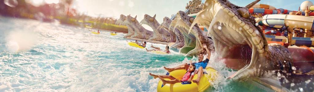 a group of people riding a water slide on a roller coaster at Crowne Plaza Yas Island by IHG in Abu Dhabi
