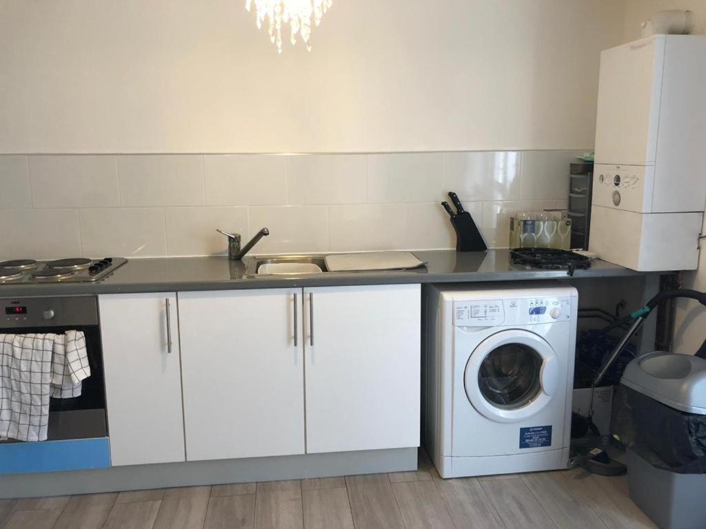 a kitchen with a washing machine under a counter at 29a Margate in Kent