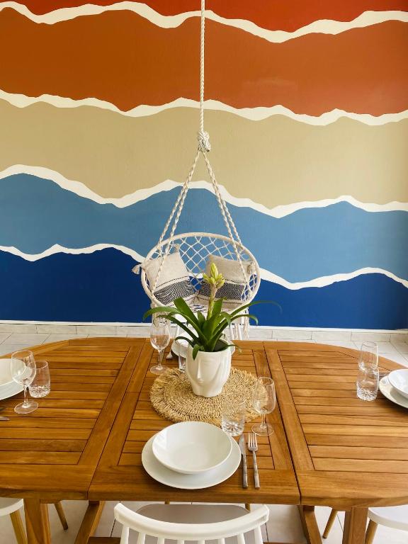 a dining room with a table and a hanging chair at Appartement cosy à Grand Case, proche aéroport. in Grand Case
