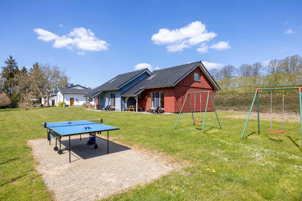 a ping pong table and swing set in a yard at Ostsee Landurlaub auf dem Ferienhof OFC 21 in Kröpelin