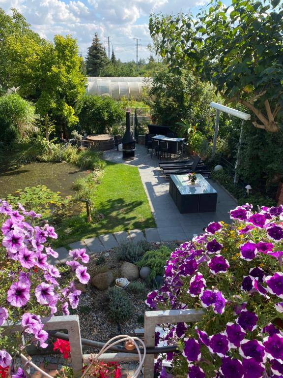 a garden with purple flowers and a table and benches at Ferienwohnung Müller in Stendal