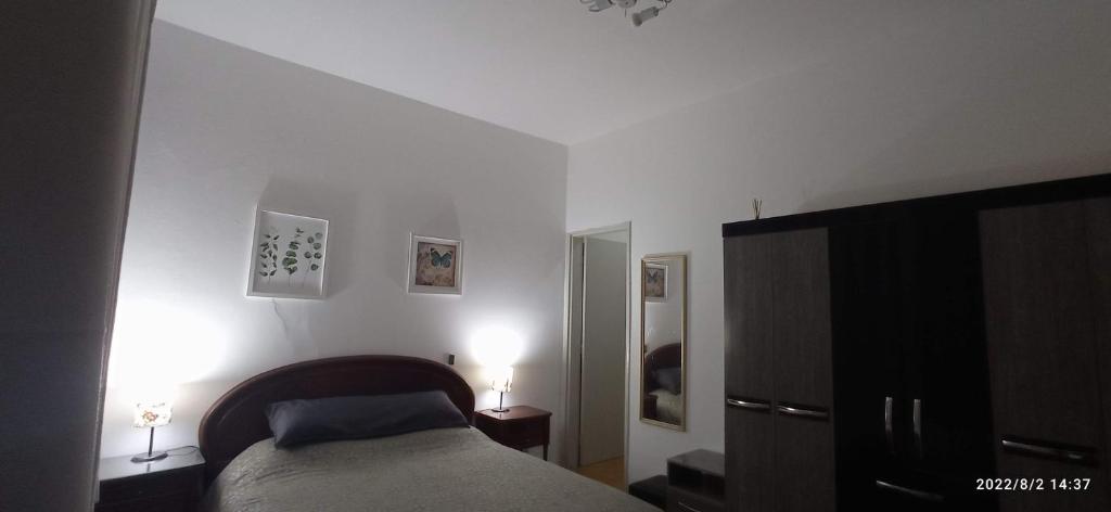 安帕羅的住宿－Casa Rosário Centro de Amparo，一间卧室配有床和两盏灯