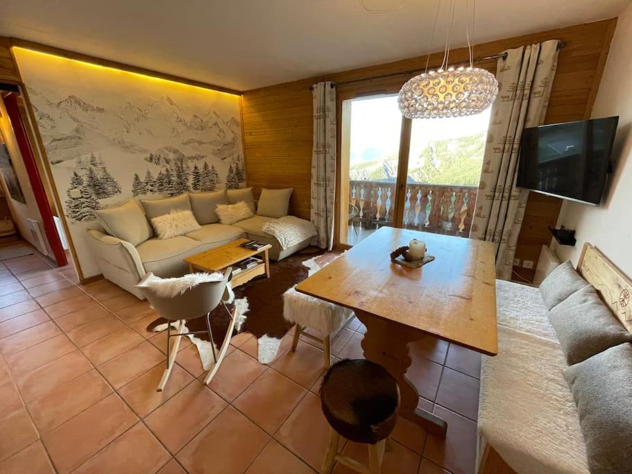 sala de estar con sofá y mesa en Appartement COSY à Praloup, 43m2, vue magnifique en Uvernet-Fours