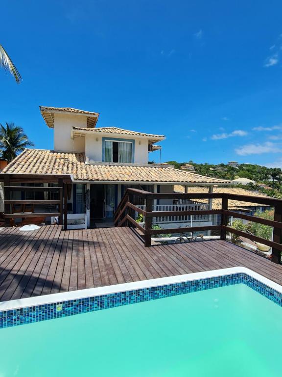 a villa with a swimming pool in front of a house at Pousada Solar da Ferradurinha in Búzios