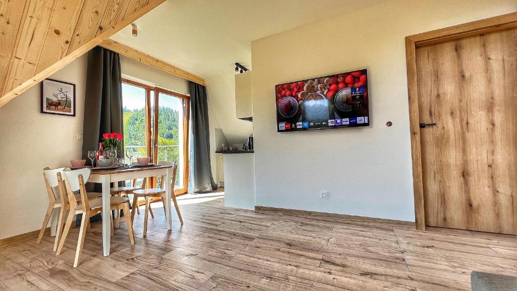 Televízia a/alebo spoločenská miestnosť v ubytovaní Apartamenty Widok Tatr