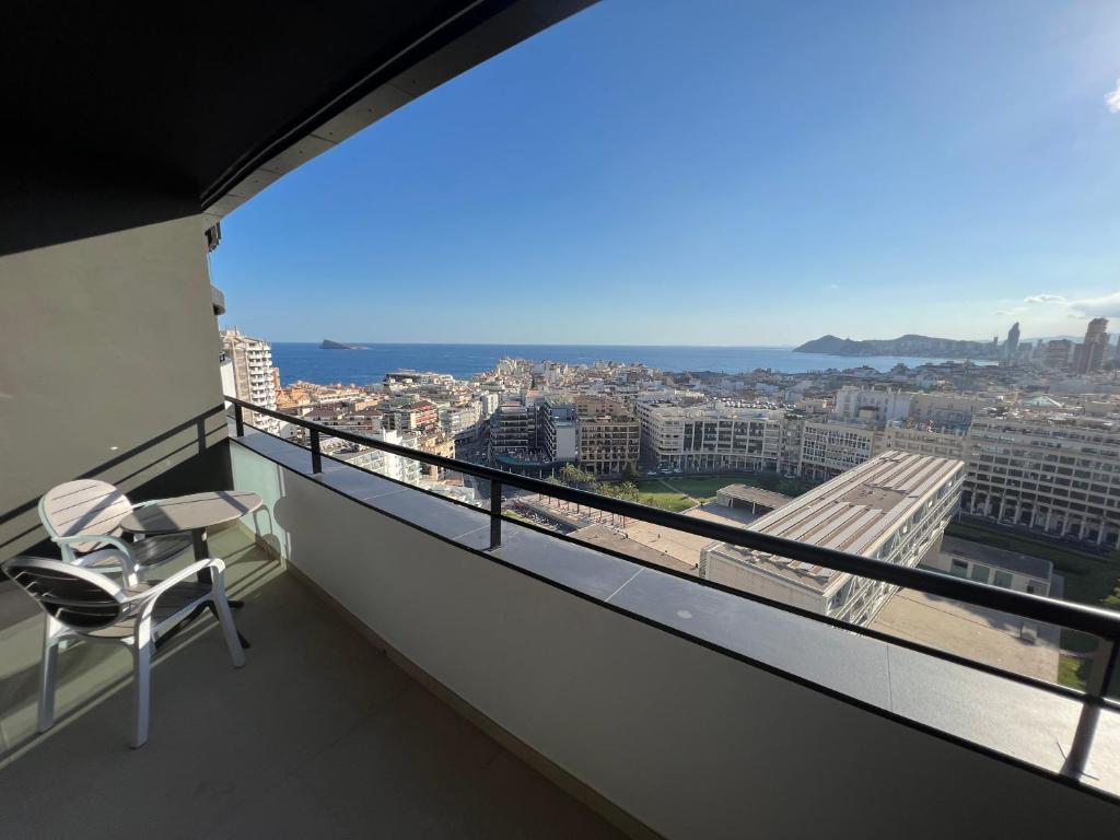 a balcony with a chair and a view of a city at Hotel Primavera Park in Benidorm