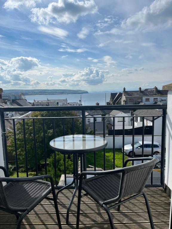 a patio with two chairs and a table on a balcony at Seaview Haven in Portstewart