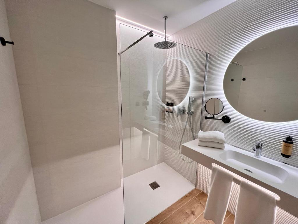 a white bathroom with a sink and a mirror at Hotel Primavera Park in Benidorm