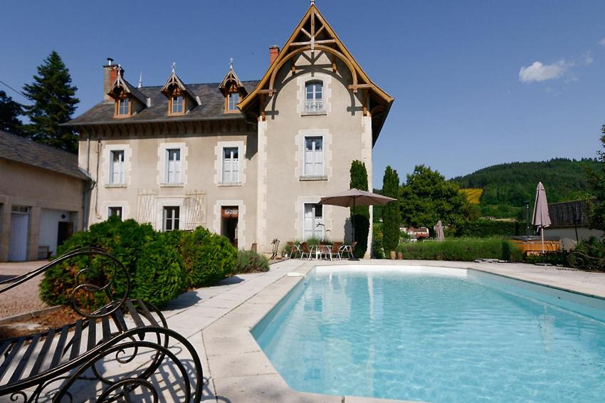 een huis met een zwembad voor een gebouw bij Château d'Arfeuilles Chambres et tables d'hôtes in Arfeuilles