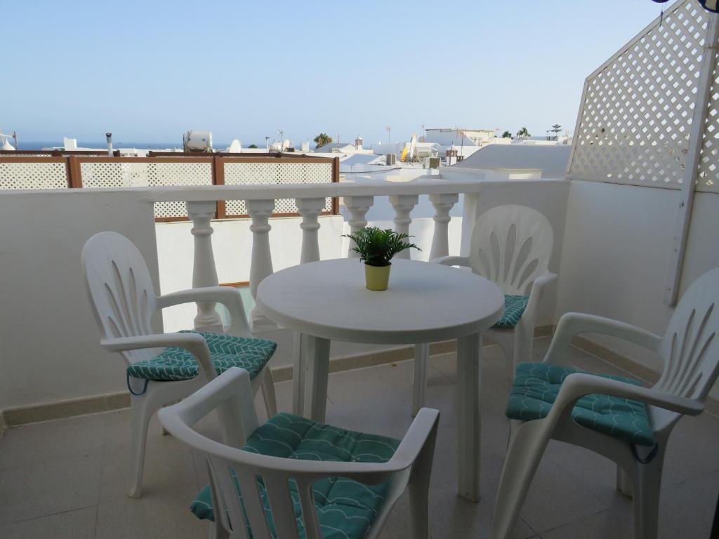 a table and chairs on a balcony with the view of the ocean at lidl Bright Central Two Bed Apartment PDC in Puerto del Carmen