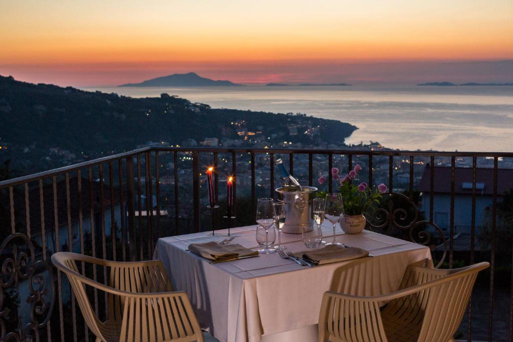 a table on a balcony with a view of the ocean at Villa Pane Resort in Sorrento