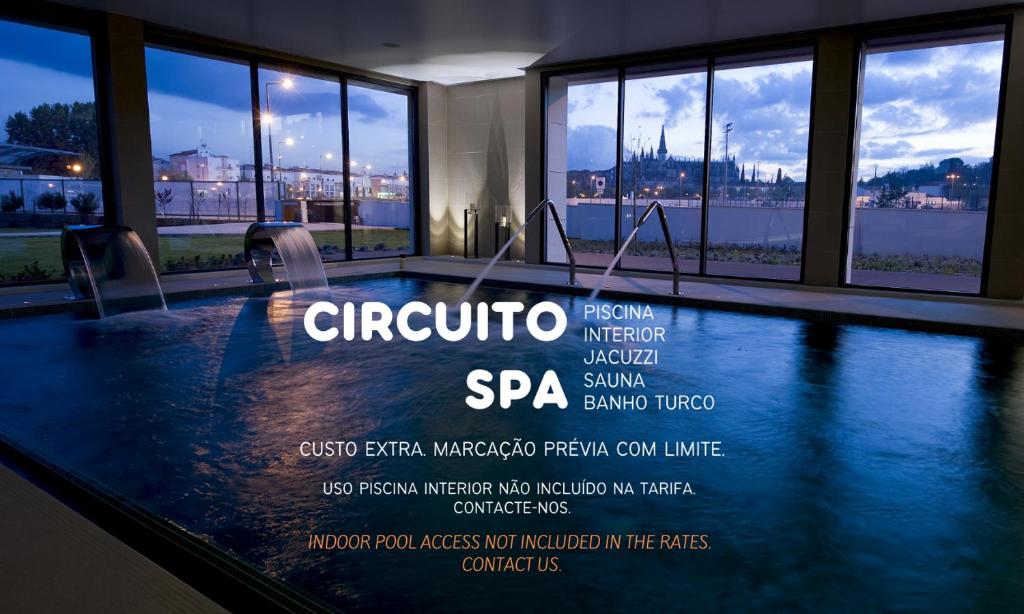 een zwembad in een gebouw met ramen bij Hotel Villa Batalha in Batalha