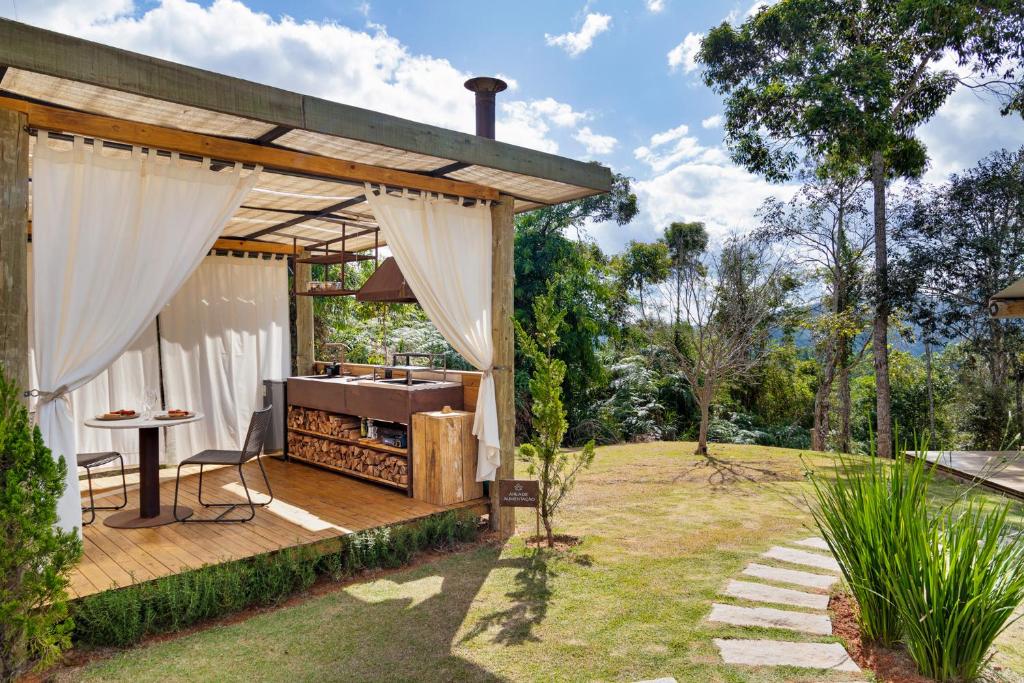 a wooden deck with a grill in a garden at Cabanas do Vale in Araras Petropolis