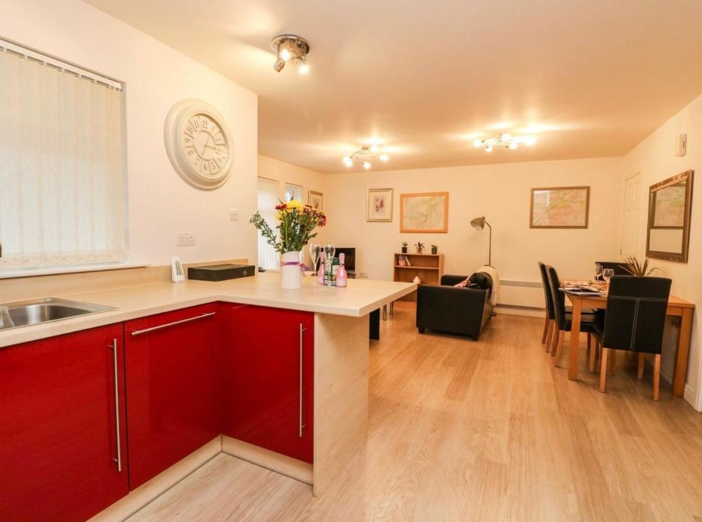 a kitchen with red cabinets and a dining room at SCOTTISH HIGHLANDS Superb 2 bedroom apartment. in Invergarry