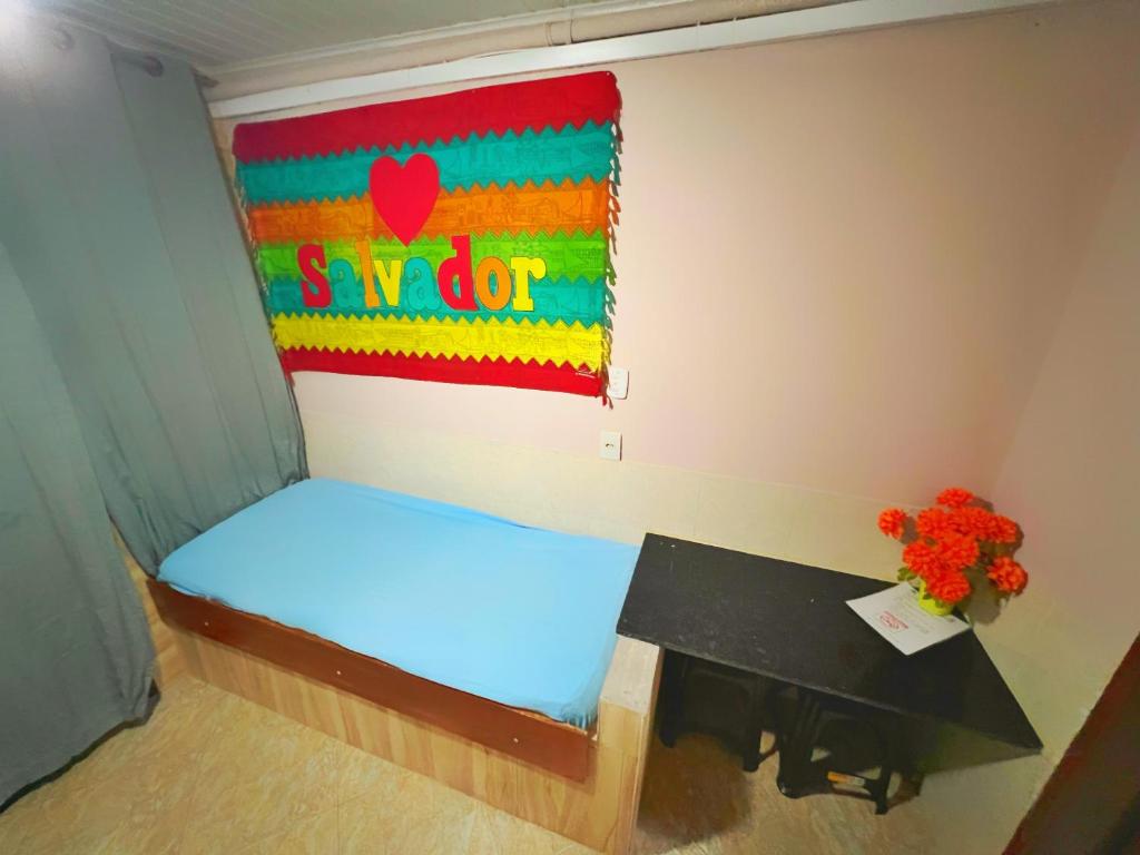 a room with a bed with a sign on the wall at Apartamento Praia em Salvador Terreo in Salvador