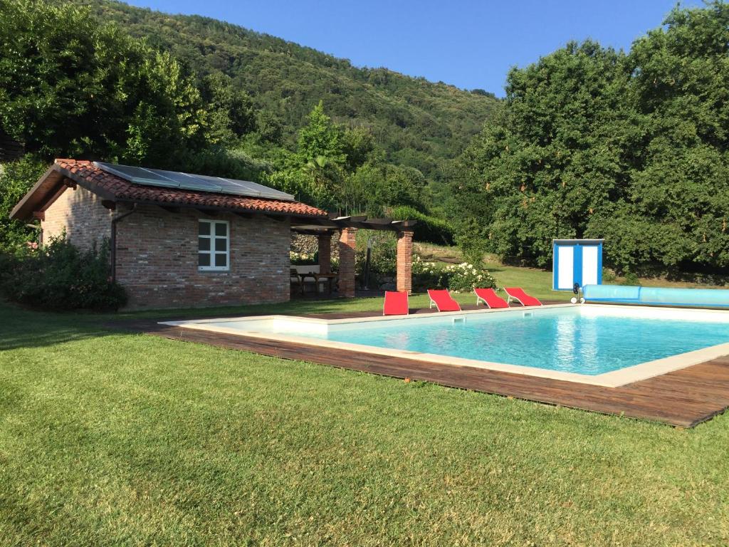 een zwembad met stoelen naast een huis bij MyVilla B&B in Palazzo Canavese