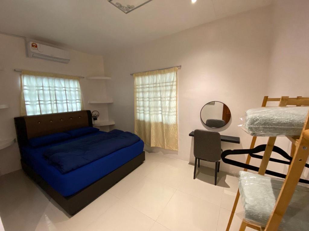 a bedroom with a blue bed and a mirror at Beautiful River Homestay & Room Mersing in Mersing