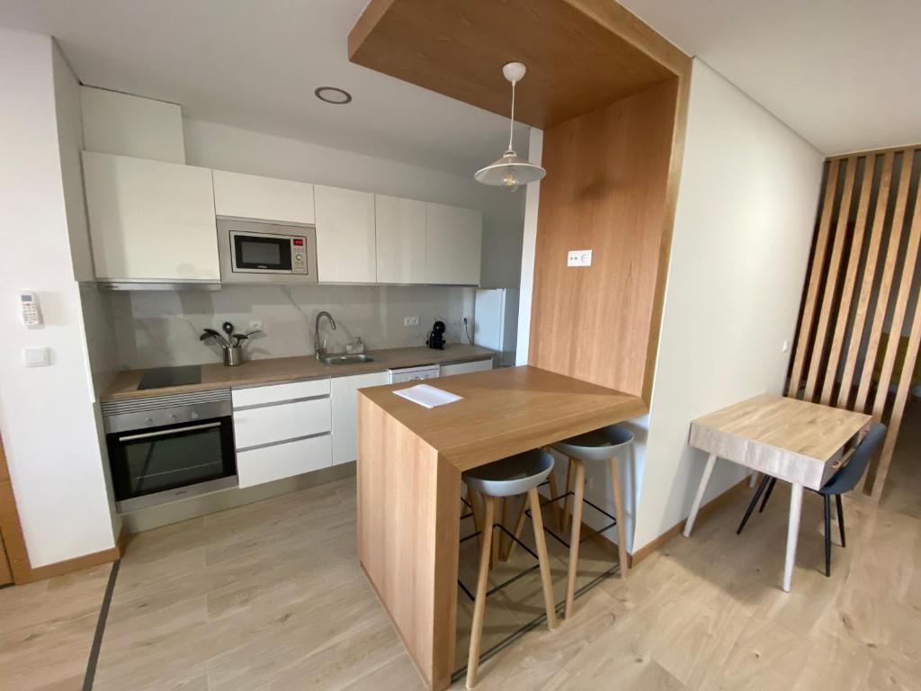 a kitchen with a wooden table and a counter at IPB Studios in Bragança