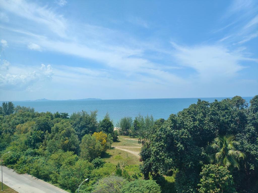 een uitzicht op een weg en de oceaan met bomen bij Sutra Damai Seaview in Kuantan