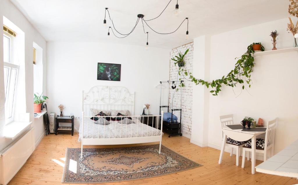 a white room with a crib and a table at White Lodge - central beach apartment in Liepāja