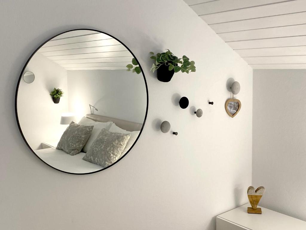 a round mirror on a white wall in a bedroom at Studio Tara with balcony in Bled