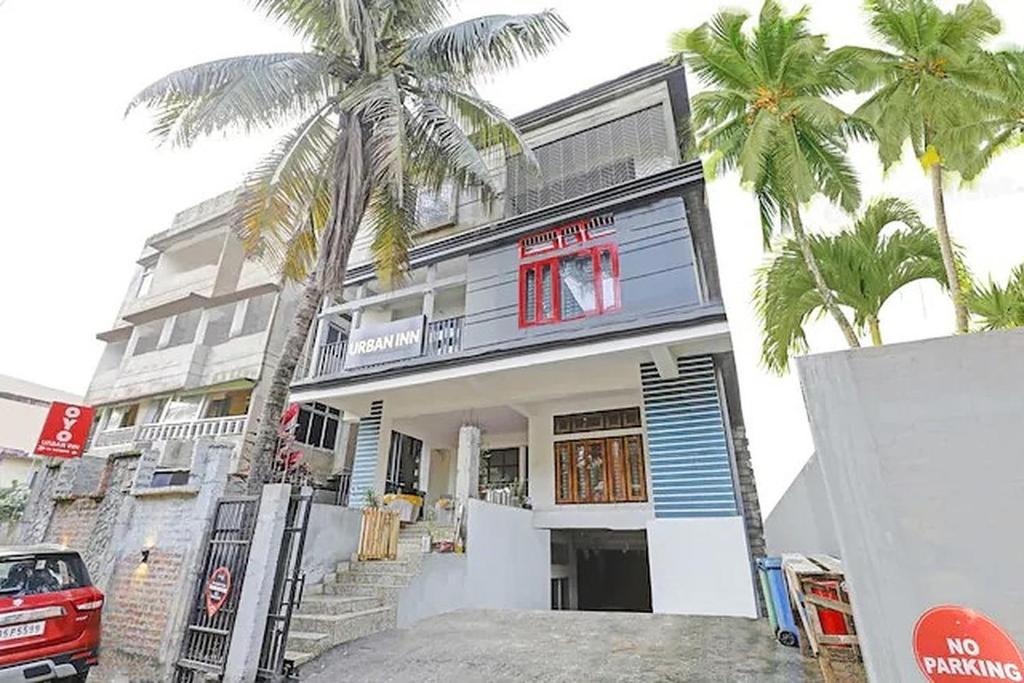 a house with palm trees in front of it at Urban Inn Rukminigaon in Guwahati