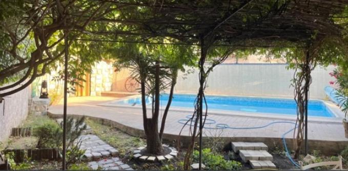 Blick auf einen Pool mit Bäumen im Hof in der Unterkunft Le clos Roby maison avec piscine proche du centre historique in Pézenas