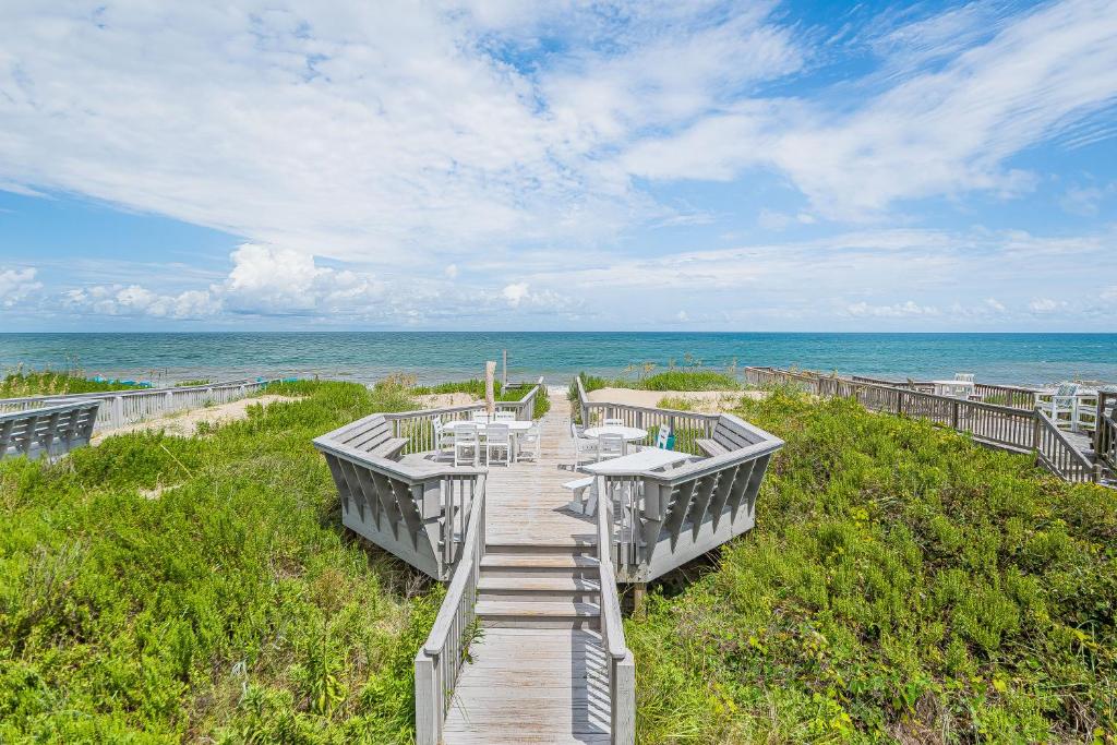 a boardwalk leading to a beach with the ocean at Dunes for Days - Nags Head MP 12.5, Oceanfront, Hot Tub, Rec Room, Pets OK, YR Flex in Nags Head