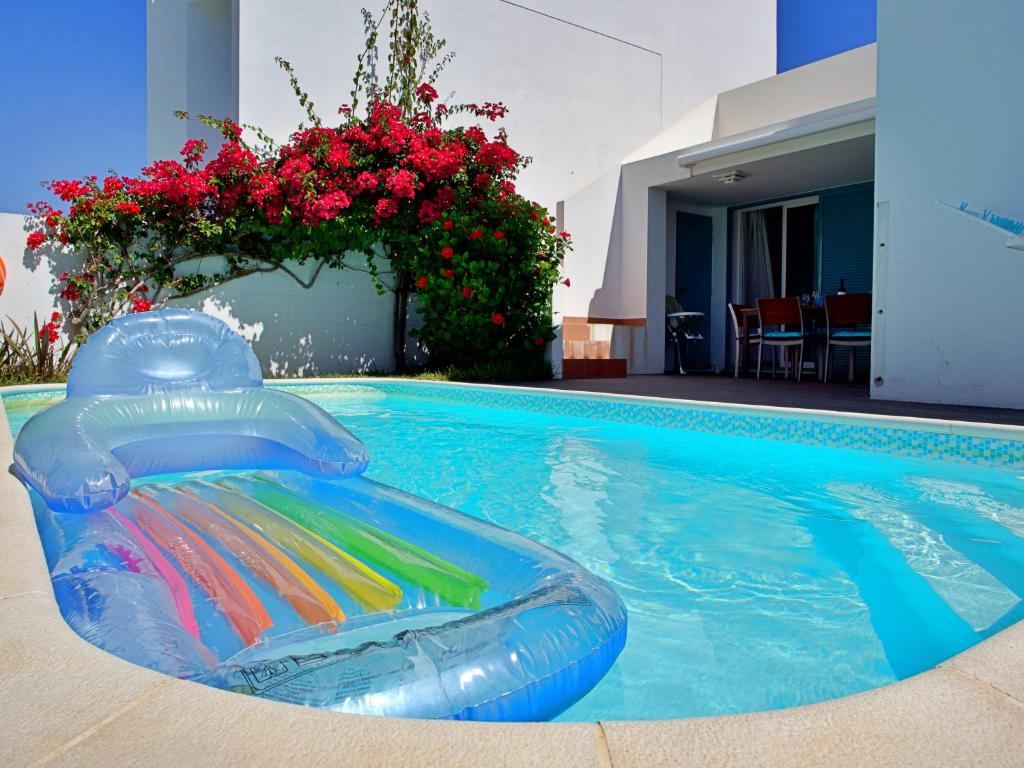 a swimming pool with a inflatable pool noodle in a swimming pool at Casa da Prainha - private pool, next to the beach in Alvor