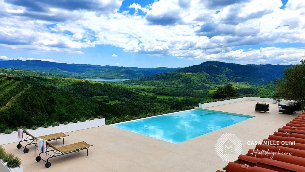 a swimming pool with a view of the mountains at Casa mille olivi in Buzet