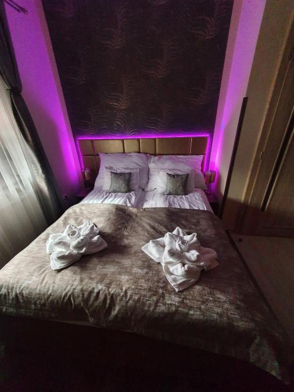 Una cama con luces moradas encima. en Harmony apartments en Mórahalom