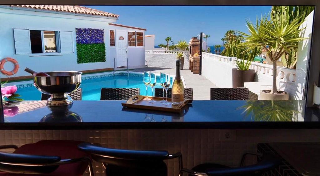 een televisiescherm met een foto van een huis met een zwembad bij Villa Casa Amada in Callao Salvaje