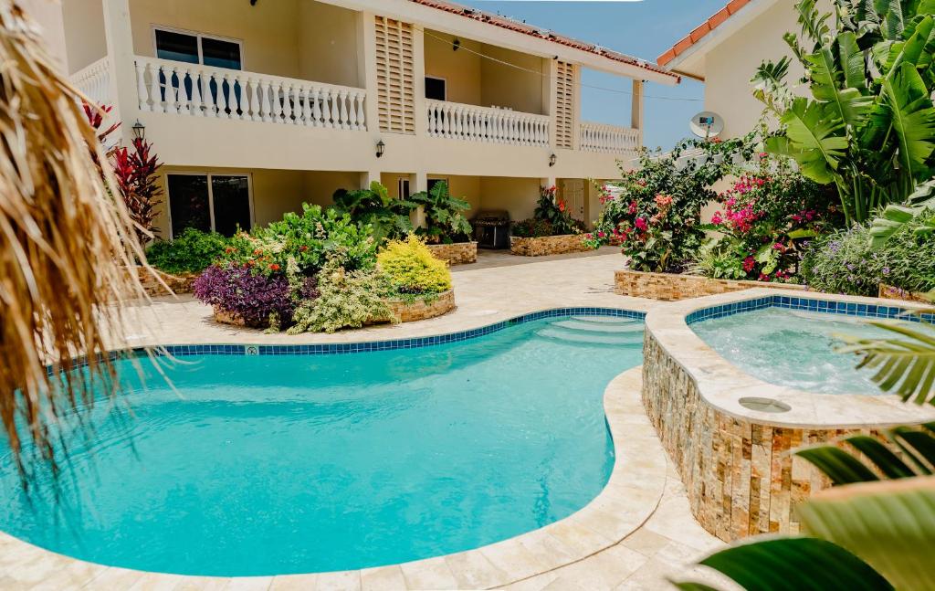 a swimming pool in a yard with a house at Brand new 2-bedroom apartment 2 km from Eagle beach in Palm-Eagle Beach