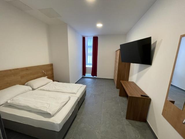 a bedroom with a bed and a flat screen tv at Wels Inn City Apartments in Wels