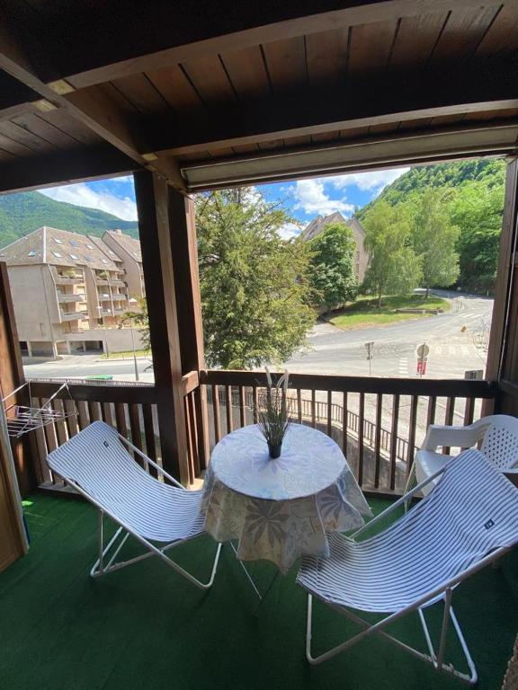 uma mesa e 2 cadeiras numa varanda com vista em T2 bis au pied des montagnes em Saint-Mamet