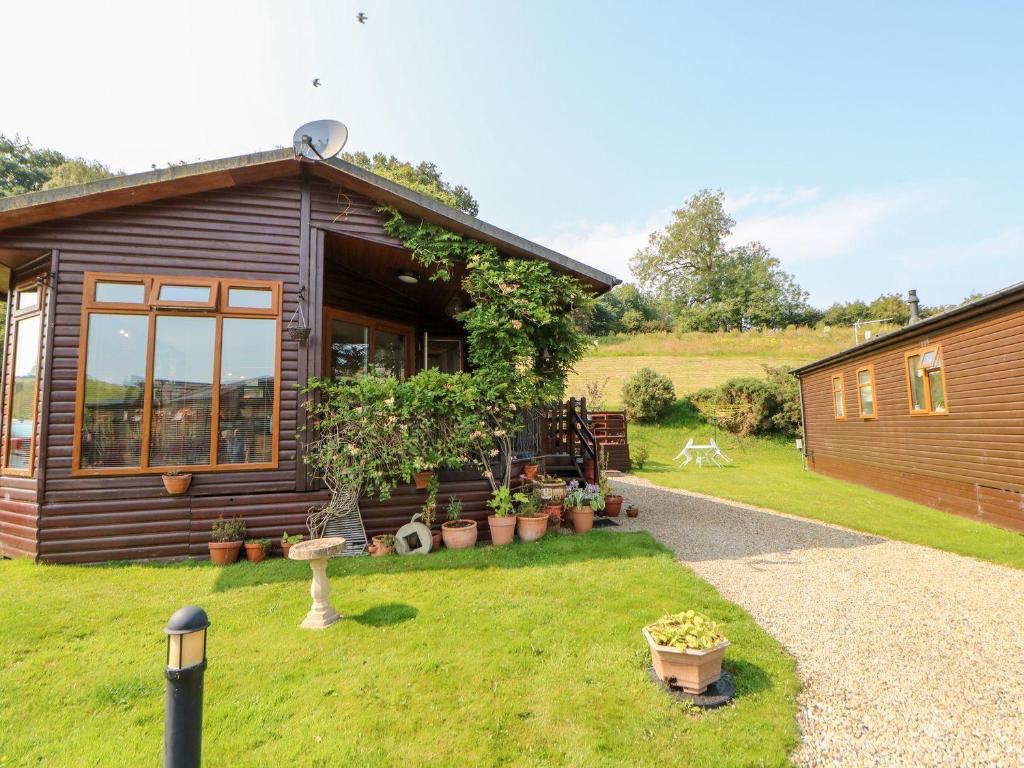 a log cabin with a garden and a lawn at 6 Badgers Retreat in Richmond