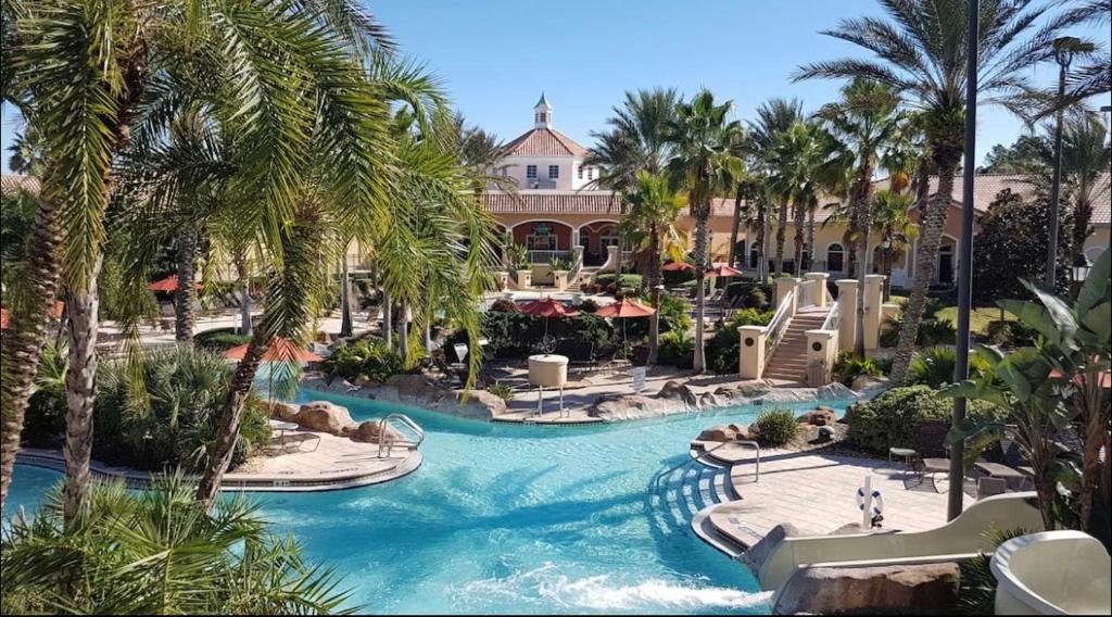 a pool at a resort with palm trees at Serene family friendly townhouse in the wonderful Regal Palms in Davenport