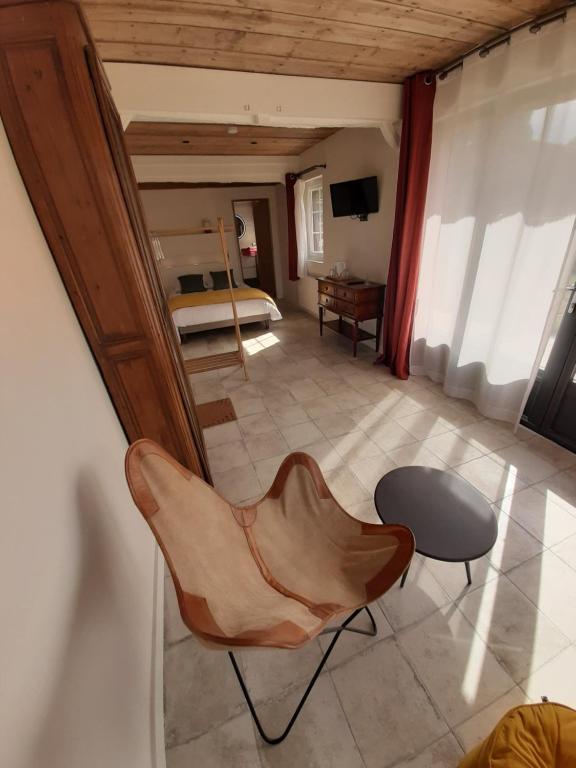 salon z krzesłem i stołem w obiekcie La Hulotière w mieście Saint-Pierre-du-Val
