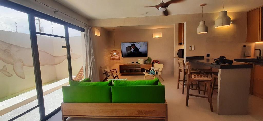 ラパスにあるMANGLITO MANILAのリビングルーム(緑のソファ付)、キッチンが備わります。