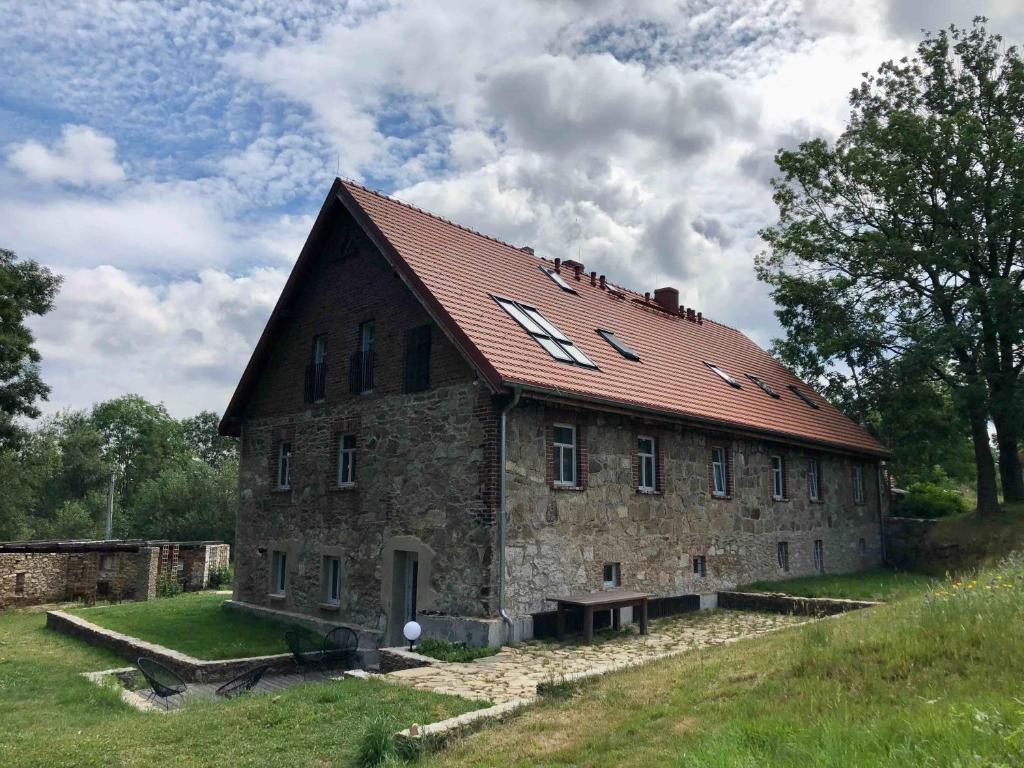 にあるMałaKamienica80 Butikowa agroturystyka w Górach Izerskichの赤い屋根の古い石造りの建物