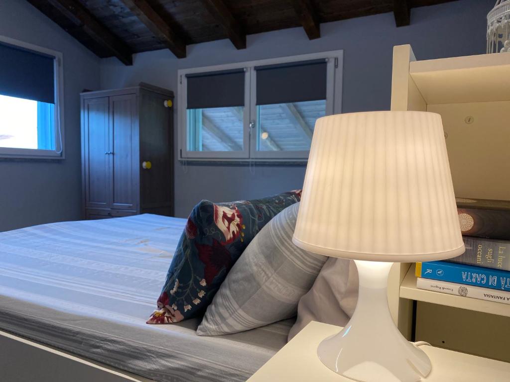 Un dormitorio con una cama con una lámpara al lado en Suite in Oltrepo’ Pavese, en Montescano